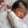 A newborn baby sleeping peacefully, wrapped in a white blanket. Anteprima dell’immagine prodotto