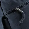 A close-up view of a zipper on a dark blue fabric bag. Voir les images du produit