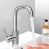 A close-up shot of a modern stainless steel faucet with water running into a sink, with a bottle of hand soap in the background. Náhled obrázku produktu