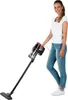 A woman is holding a cordless vacuum cleaner. Produktbild-Vorschau