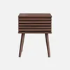 A single brown wooden nightstand with a slatted front and four tapered legs, presented against a plain white background. Produktbild-Vorschau