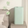 A light green air purifier is placed on a nightstand next to a bed. There are informational icons and text around the air purifier. Produktbild-Vorschau