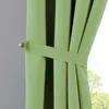 A close-up view of a green curtain with a tie-back. Produktbild-Vorschau
