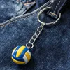 A close-up of a volleyball keychain attached to a pair of blue jeans. Produktbild-Vorschau