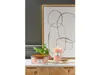 Two candles and a plant are displayed on a dresser in front of a piece of abstract art. Podgląd zdjęcia produktu