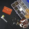 A collection of leather rivets and tools laid out on a black surface. Produktbild-Vorschau