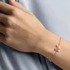 A close-up shot of a person's arm wearing a rose gold bracelet with a swan charm. Produktbild-Vorschau