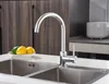 A modern kitchen sink with a chrome faucet and a bowl of lemons and limes. Anteprima dell’immagine prodotto