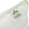 A close-up of a white pillow with a green stitched edge and a label. Produktbild-Vorschau