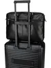 A black leather briefcase is placed on top of a black rolling suitcase, with the briefcase's strap secured around the suitcase's handle. Produktbild-Vorschau