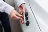 A person is using a dent repair tool on a white car. Produktbild-Vorschau