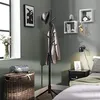 A bedroom scene with a coat rack, basket, and bed. Podgląd zdjęcia produktu