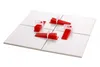 Four white tiles are arranged in a square, with red and white tile leveling tools placed on top of them. Anteprima dell’immagine prodotto