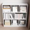 A white bookshelf filled with various items like books, boxes, and a calendar. Podgląd zdjęcia produktu