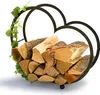 A heart-shaped metal firewood rack filled with logs, decorated with a green vine. Produktbild-Vorschau