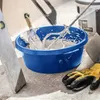 A blue bucket filled with white plaster or mortar, with tools and gloves nearby, suggesting construction or DIY work. Podgląd zdjęcia produktu