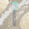 A spatula is placed on a surface dusted with flour, with two balls of dough on either side. Anteprima dell’immagine prodotto