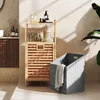 A bathroom scene with a wooden shelf unit and a laundry basket. Voir les images du produit