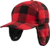 A red and black buffalo plaid winter cap with ear flaps is shown against a white background. Produktbild-Vorschau
