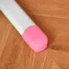 Close-up of a white table leg with a pink cap on a wooden floor. Produktbild-Vorschau