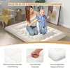 A woman and a baby are on a floor mattress in a room. Produktbild-Vorschau