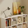 A white bookshelf filled with books and decorative items, including a desk lamp and a painting. Podgląd zdjęcia produktu