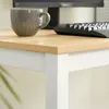 A close-up of a desk corner with a monitor, keyboard, and mug. Produktbild-Vorschau