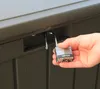 A hand is holding an open padlock near a brown storage box. Produktbild-Vorschau
