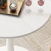 A close-up view of a white round table with two wine glasses and a decorative tray with a bottle and a sphere on it. Anteprima dell’immagine prodotto