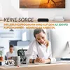 A woman is working at a desk while on the phone, with a TV and a set-top box in the background. Produktbild-Vorschau