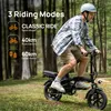 A man riding a black foldable electric bike in a grassy, wooded area. Produktbild-Vorschau
