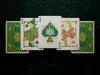 A set of playing cards with a fantasy theme, featuring a castle design on the Ace of Spades and illustrated characters on the Queen cards, laid out on a dark, textured surface. Náhled obrázku produktu