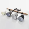 A disassembled pendant lamp with four lampshades in different colors and a wooden beam with mounting hardware. Produktbild-Vorschau