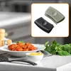 A close-up shot of two silicone pot handle covers, one black and one gray, displayed in an inset box. The main image shows a plate of food and a small bowl of shredded cheese on a countertop. Produktbild-Vorschau