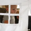 A child looks out of a window in a white tent. Produktbild-Vorschau