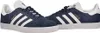 A pair of navy blue Adidas Gazelle sneakers with white stripes and soles, shown from a side-angle. Produktbild-Vorschau