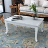 A white coffee table with books and a vase of tulips on it, placed on a patterned rug in a living room setting. Náhľad obrázku produktu