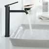 A black faucet is installed above a sink, with water flowing into it. Podgląd zdjęcia produktu