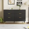 A modern black dresser with gold accents is displayed in a well-lit room with artwork on the wall and a floor lamp. Podgląd zdjęcia produktu