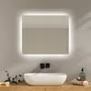A modern bathroom vanity with a backlit mirror, sink, and wooden countertop.