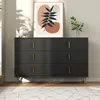 A modern black dresser with gold accents is displayed in a well-lit room, with artwork and a vase of flowers on top. Podgląd zdjęcia produktu