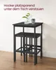 A black bar table set with two stools tucked underneath, placed against a light-colored wall. Produktbild-Vorschau