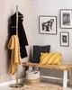 A stylish entryway with a gold coat rack, a wooden bench with pillows, and framed art on the wall. Náhled obrázku produktu