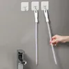 Two cleaning brushes hanging on hooks above a sink faucet. Produktbild-Vorschau