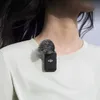 A person wearing a white t-shirt with a DJI microphone attached to the collar. Náhled obrázku produktu