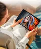 A person is holding a tablet and looking at it while sitting in a chair. Produktbild-Vorschau