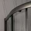 A close-up view of a curved shower door frame and glass panels against a textured wall. Produktbild-Vorschau