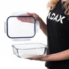 A person is holding the lid of a glass food storage container above the base. Anteprima dell’immagine prodotto