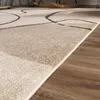 A close-up view of a rug with an abstract geometric pattern, showing the texture and edge detail. Produktbild-Vorschau
