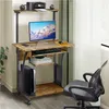 A computer desk with a monitor, keyboard, printer, and speakers is set up in a room with a window and curtains. Produktbild-Vorschau